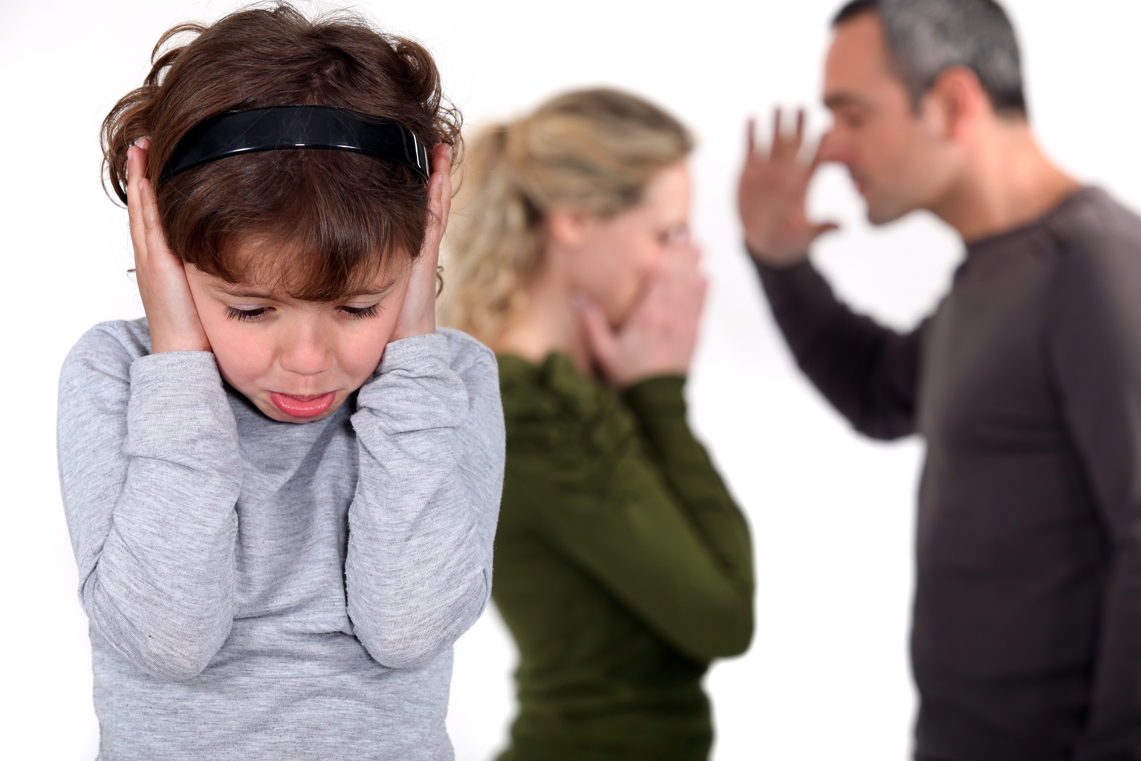 child covering ear while parents fight